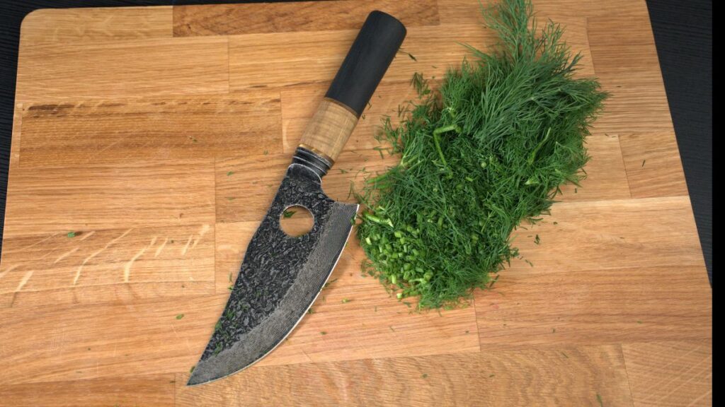 Matsato Osuren chef’s knife beside chopped herbs on a wooden cutting board